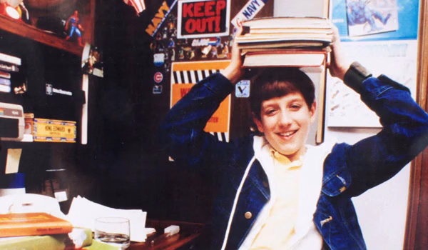 student balancing books on his head